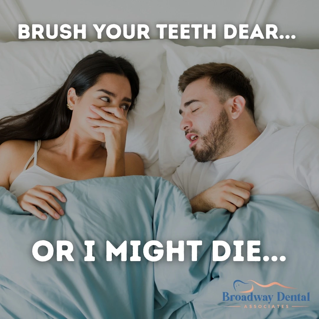 A couple in bed, with the woman holding her hand over her mouth, highlighting the humorous consequences of bad breath