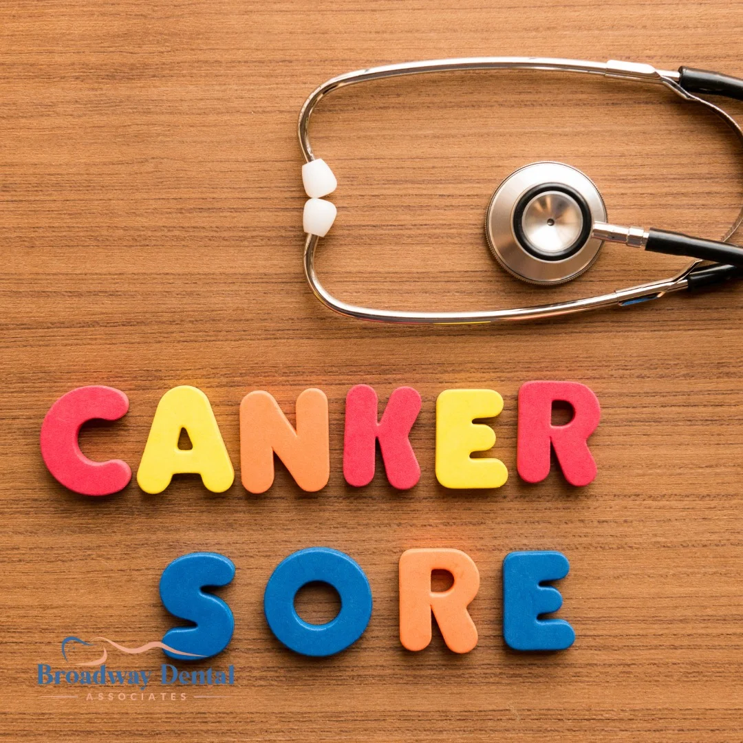 Colorful blocks spelling canker sore on wood and Broadway Dental Associates logo in the bottom left of the image.