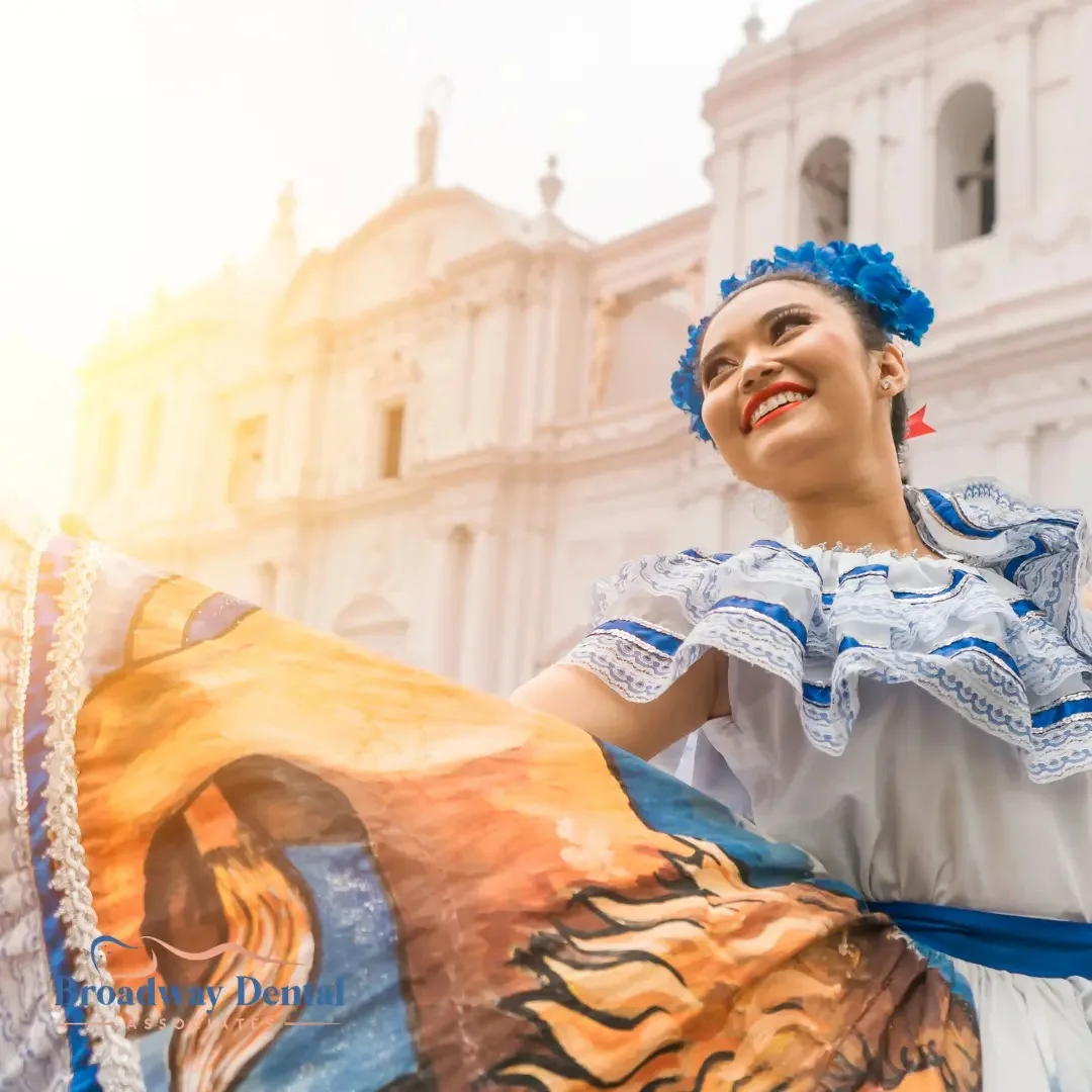 Woman in traditional dress dancing and Broadway Dental Associates logo in the bottom left of the image.