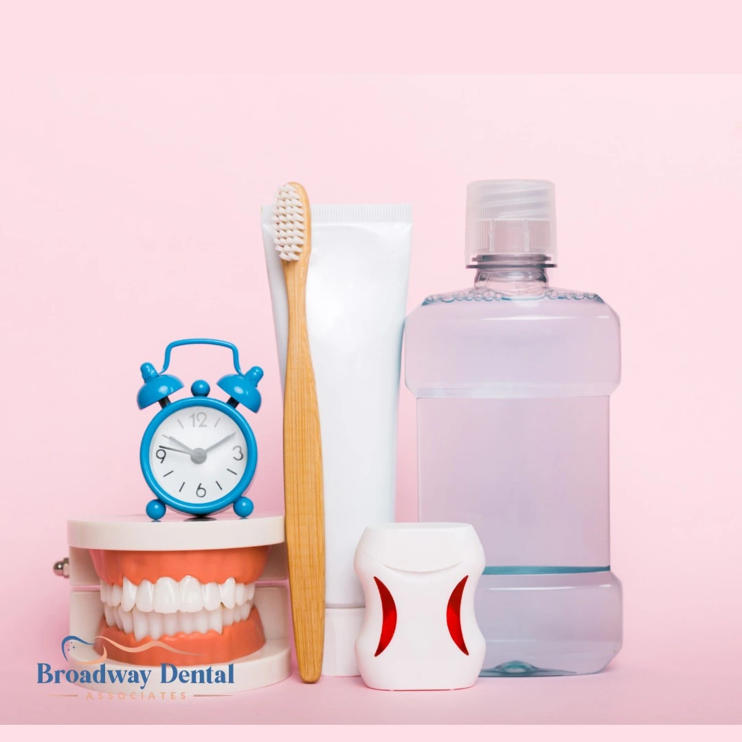 Toothbrush, mouthwash, dental model, and clock and Broadway Dental Associates logo in the bottom left of the image